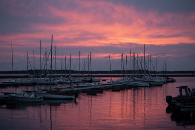 Boats moored in harbor during sunset