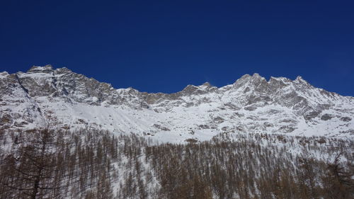 Scenic view of snowcapped mountains against clear blue sky