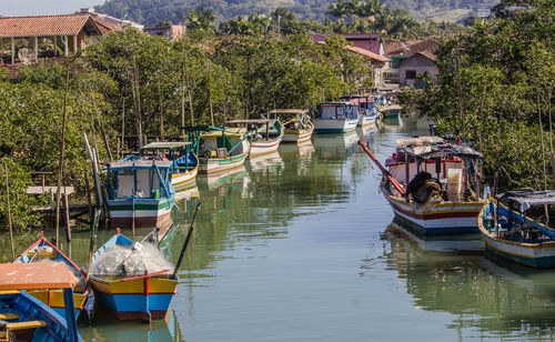 Boats moored in river by buildings