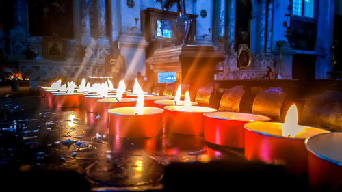 Close-up of illuminated candles on table at night