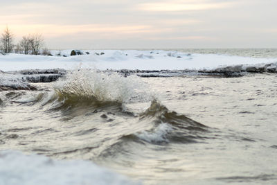 Winter landscape from the sea shore, blurred wave slag against frozen ice cubes, blurred background