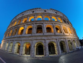 Low angle view of colosseum against clear blue sky