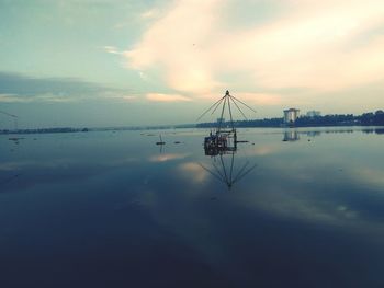 Silhouette ship in sea against sky during sunset