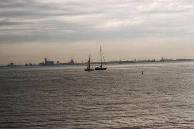 Sailboat sailing on sea against sky during sunset