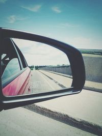 Reflection of clouds in side-view mirror