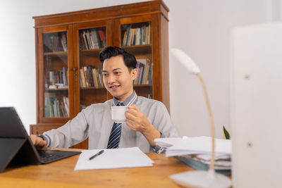 Portrait of young woman sitting on table