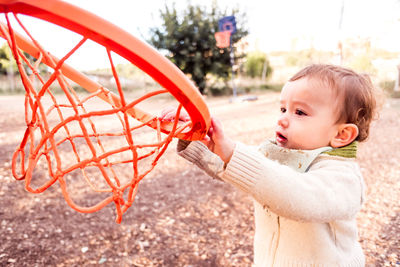 Cute baby girl holding basketball hoop