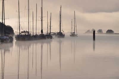 Boats moored on sea against sky