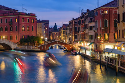 View of canal amidst buildings in city at night