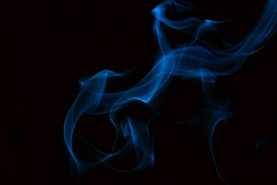 Close-up of blue smoke against black background