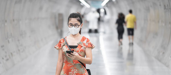 Woman holding smart phone in subway