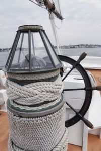 Close-up of boat moored at harbor against sky