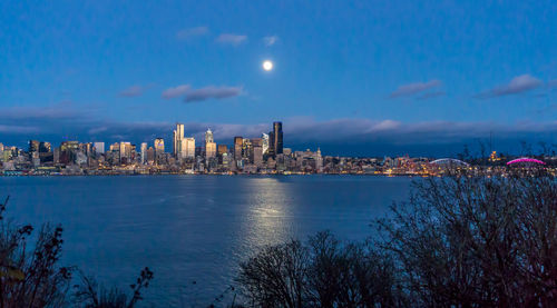 A bright full moon shines over the seattle skyline.