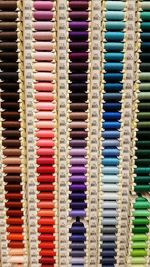 Full frame shot of colorful thread spools arranged for sale