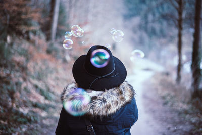 Close-up of woman blowing soap bubbles on snow