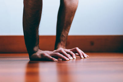 Cropped image of hand on hardwood floor