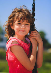 Portrait of cute girl holding rope against sky