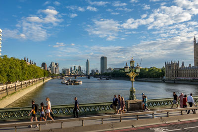 People on bridge over river in city