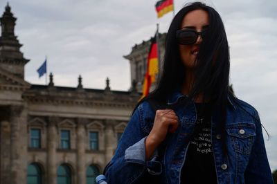 Young woman standing outside reichstag building in city