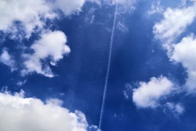 Low angle view of vapor trail against blue sky