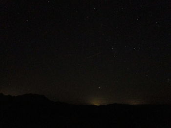Low angle view of silhouette mountain against sky at night