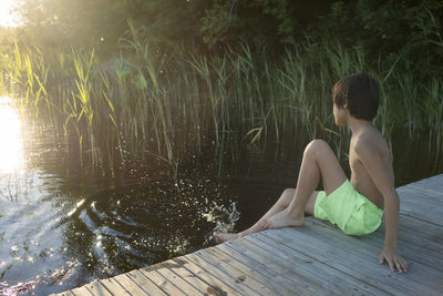 Boy sitting on jetty