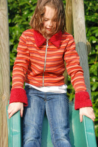 Girl sitting on slide in playground