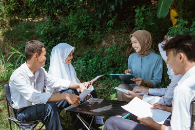 Side view of friends using digital tablet