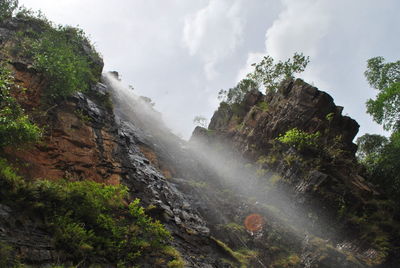 Low angle view of waterfall against sky