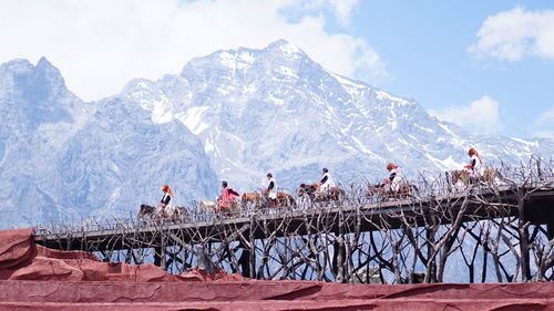 People on snowcapped mountain against sky