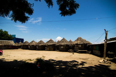 Houses by trees against blue sky