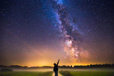 Man standing against star field at night