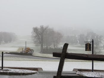 Snow covered landscape against sky during foggy weather