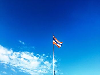 Low angle view of flag against blue sky