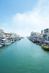 Boats in river with buildings in background