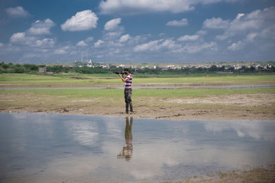 Full length of man standing on field against sky