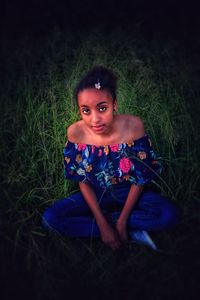 Portrait of woman sitting on field