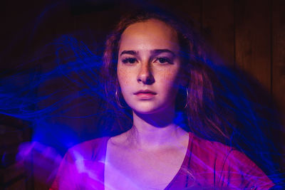 Portrait of beautiful young woman against wall