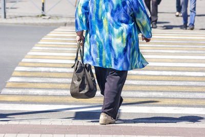 Low section of man walking on road