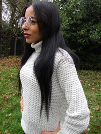 Beautiful young woman standing against plants