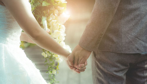 Midsection of couple holding hands