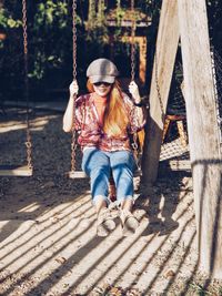 Full length of woman sitting on swing outdoors