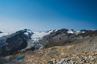 Scenic view of snowcapped mountains against blue sky