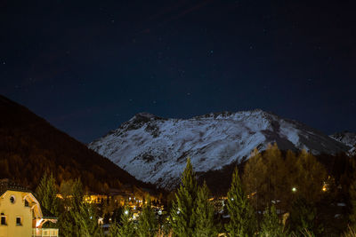 Scenic view of snowcapped mountain against sky at night