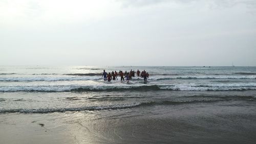 People at beach against sky