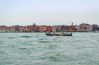 Boats in sea against clear sky