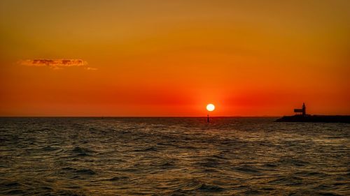 Scenic view of sea against orange sky