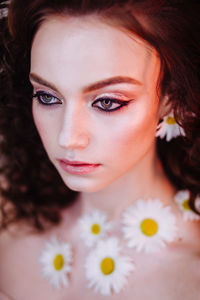 Close-up of beautiful young woman wearing flowers and make-up