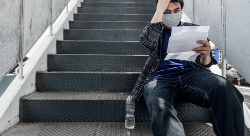 Full length of man sitting on staircase