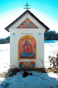 View of cross on field against sky during winter